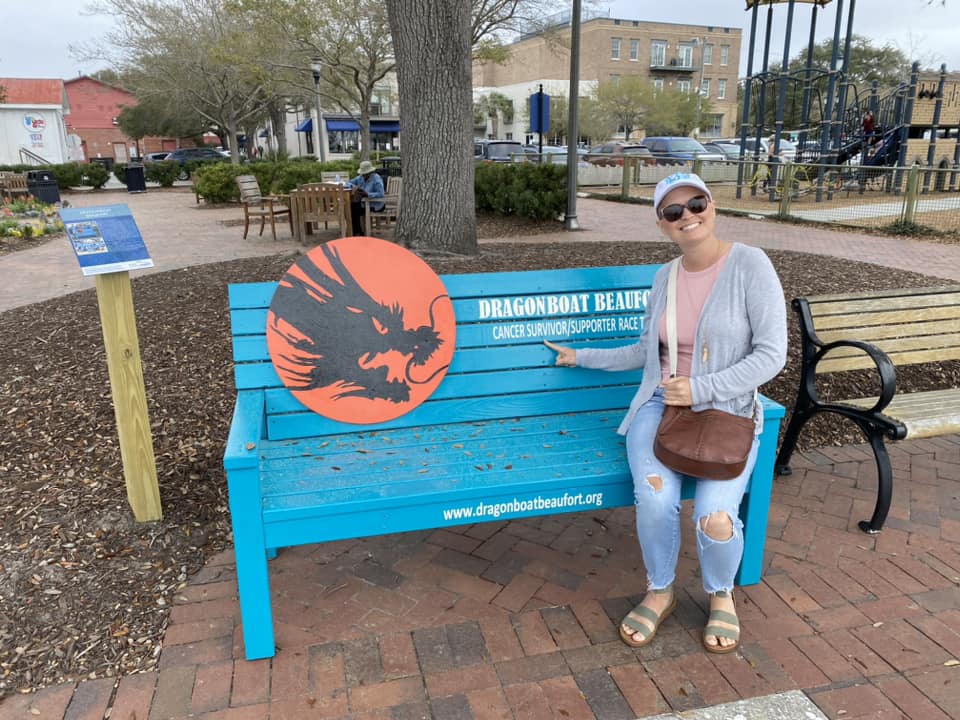 woman pointing to cancer survivor sign on bench