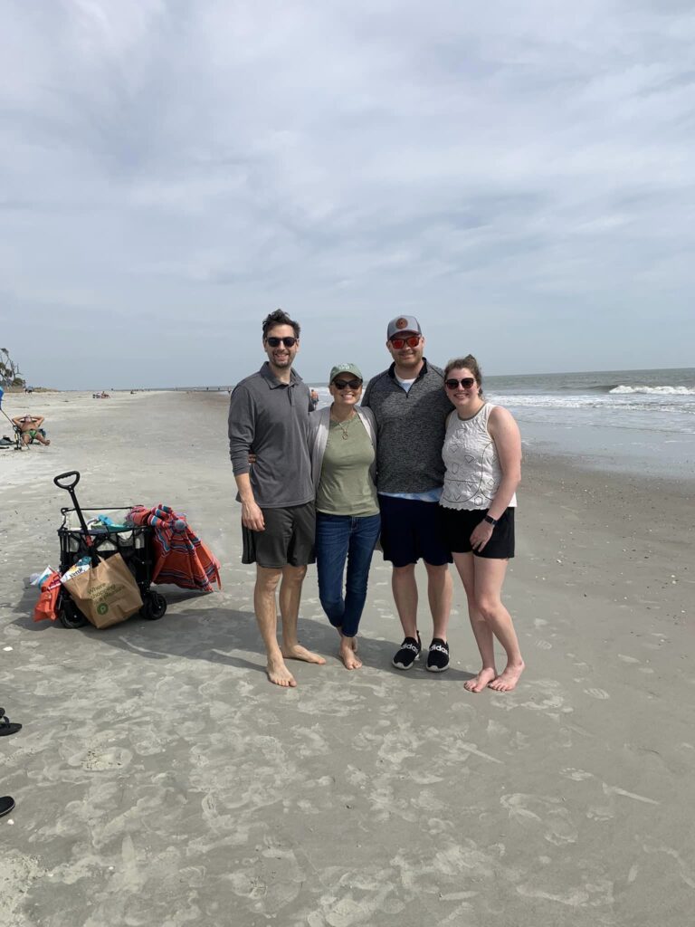 Two couples posing for picture on beach