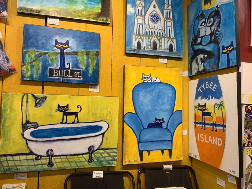 A number of Pete the Cat paintings line a bright yellow wall