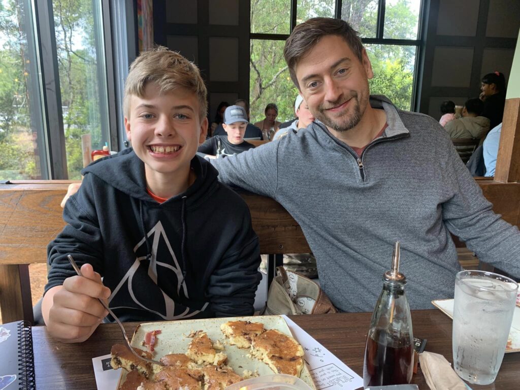 Father and son smiling in restuarant