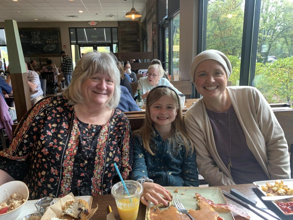 Grandmother, mother, and daughter posing for picture in restaurant