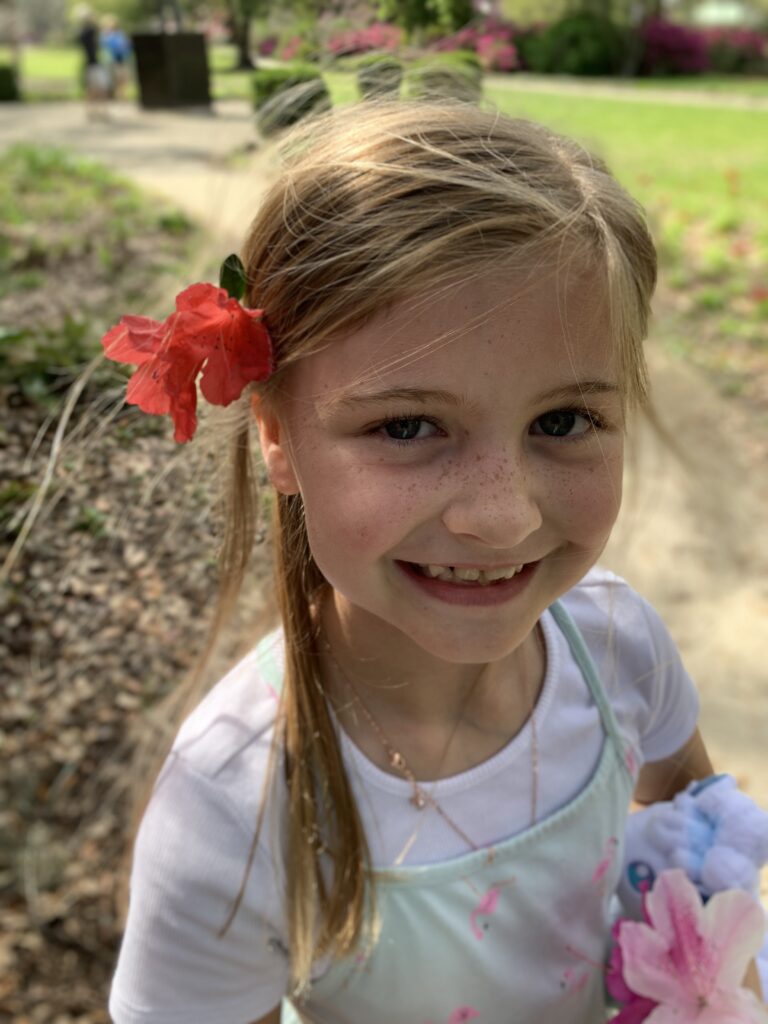 Smiling girl with a red azalea in her hair
